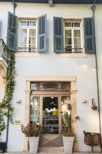 a white building with blue shuttered windows and a door at Atelier Residences by Sweet Keys in Limassol