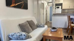 a living room with a white couch and a table at Maysan Apartamento in Benidorm