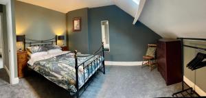 ein Schlafzimmer mit einem Bett und einer blauen Wand in der Unterkunft Cosy Loft Apartment with Sea Views Above Village Pub The Stag Inn Crosby Maryport in Crosby