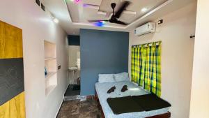 a small room with a bed and a green curtain at Shivneri Homestay in Hampi +16 photos
