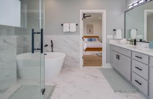 a white bathroom with a tub and a sink at HTX Modern Retreat with Rooftop Cinema in Houston +49 photos