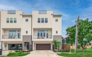 a large white house with a garage at HTX Modern Retreat with Rooftop Cinema in Houston