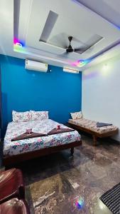 two beds in a room with a blue wall at Shivneri Homestay in Hampi