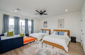 a bedroom with two beds and a ceiling fan at HTX Modern Retreat with Rooftop Cinema in Houston