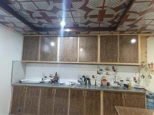 a kitchen with wooden cabinets and a tile ceiling at The Crescent Resort in Skardu