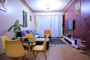 a living room with a couch and a table and chairs at AG Home - One Bedroomed Kampala in Kampala