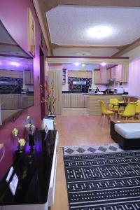 a living room with purple lighting and a kitchen at AG Home - One Bedroomed Kampala in Kampala