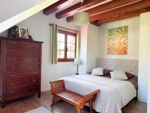 a bedroom with a large bed and a dresser at VILLA XXL - SPA & Cuisine d'été in Viarmes