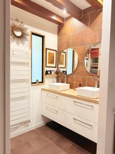 a bathroom with two sinks and two mirrors at VILLA XXL - SPA & Cuisine d'été in Viarmes