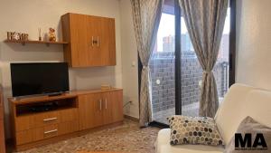 a living room with a flat screen tv on a wooden entertainment center at Maysan Apartamento in Benidorm