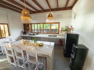 a kitchen with a table with chairs and a refrigerator at Oinan Beach Villa in Tua Pejat