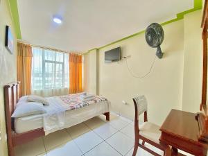 a bedroom with a bed and a desk and a fan at HOTEL CARIAMANGA in Santo Domingo de los Colorados