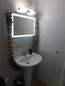 un bagno con un lavandino, uno specchio e una finestra di Mas Laborde a Mauroux
