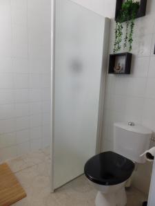 bagno con servizi igienici con seduta del water nera. di Mas Laborde a Mauroux