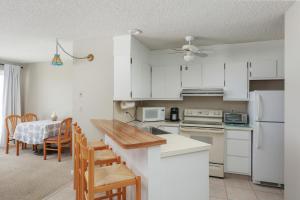 a kitchen with white cabinets and a table and chairs at Sea Breeze Beach View in Seaside Heights +7 photos
