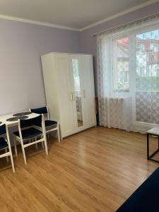 a living room with a table and chairs and a window at UPaniAni in Ustronie Morskie