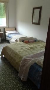 twee bedden in een slaapkamer met een spiegel bij Casa venturini in Imola