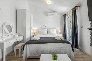 a white bedroom with a large bed and a mirror at Apartments 2 with pool and private jacuzzi in Vodice +81 photos