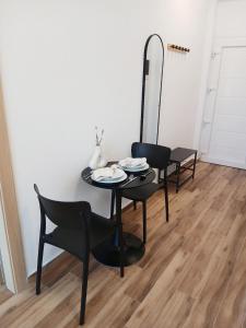 a dining room table with two chairs and a mirror at Vagia's House in Skala Rachoniou