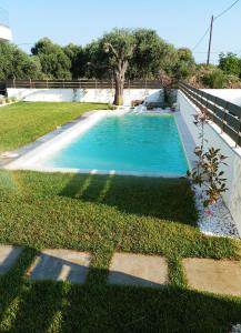 a swimming pool in the middle of a yard at Vagia's House in Skala Rachoniou