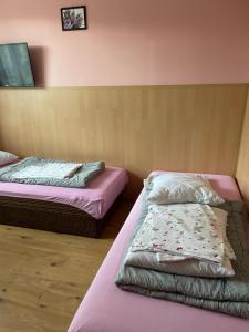 two beds in a room with pink sheets at UPaniAni in Ustronie Morskie