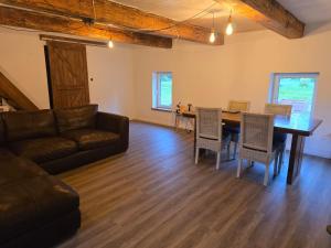 ein Wohnzimmer mit Sofa, Tisch und Stühlen in der Unterkunft Draugų sodyba in Trimputiškis