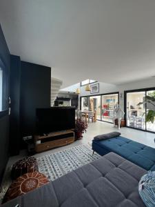 un soggiorno con divano e TV a schermo piatto di Villa des Bananiers a Baillargues Altre 44 foto