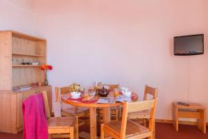 a dining room with a table with chairs and a tv at Résidence Pierre & Vacances Emeraude in Belle Plagne +24 photos