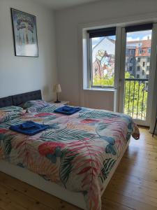 a bedroom with a bed with a colorful comforter and a window at Harbour Residence in Copenhagen