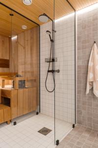 a shower with a glass door in a bathroom at Auroras by Kaltios, Gielas, Ski-in Ski-out, Mountain view in Kittilä +48 photos