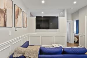 a living room with a blue couch and a flat screen tv at 2BD Urban Ease in Lower East Side in New York