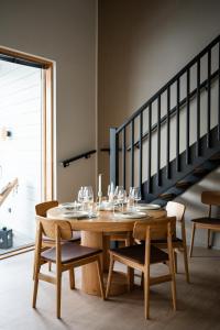 a wooden table with wine glasses on it next to a staircase at Auroras by Kaltios, Gielas, Ski-in Ski-out, Mountain view in Kittilä