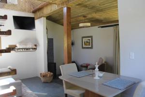 a dining room with a table and a tv at Cabanas Grande Passo in Quatro Barras