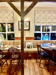 ein Esszimmer mit Tischen und Stühlen und Fenstern in der Unterkunft Cosy Loft Apartment with Sea Views Above Village Pub The Stag Inn Crosby Maryport in Crosby