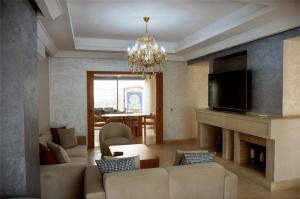 a living room with a fireplace and a chandelier at Villa 130 Spacieuse 4 chambres dar bouazza proche plage in Casablanca