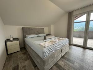 a bedroom with a large bed and a large window at Silent Retreat in Deovići