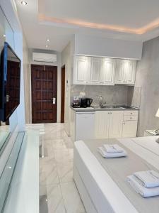a kitchen with white cabinets and a sink at Amaryllis Luxury Rooms in Platamonas