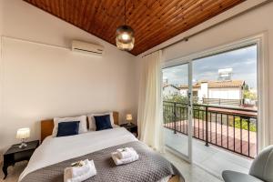 ein Schlafzimmer mit einem Bett und einem Balkon in der Unterkunft Larnaca Seaside Villa Marina 43 in Perivolia