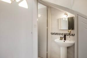 ein weißes Badezimmer mit Waschbecken und Spiegel in der Unterkunft Larnaca Seaside Villa Marina 44 in Perivolia + 24 Fotos