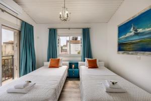 zwei Betten in einem Zimmer mit Fenster in der Unterkunft Larnaca Seaside Villa Marina 44 in Perivolia