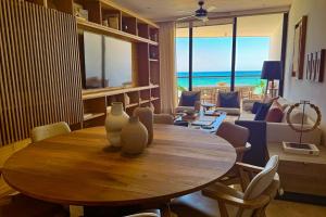 a dining room with a table and a living room with the ocean at Alonisos Luxury Apartment in San Bruno
