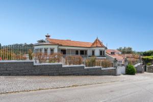a white house with a fence on a street at Calejo House – Pool & Sports & Grill Retreat in Nogueira +116 photos