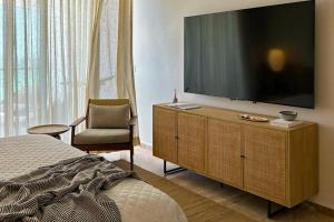 a bedroom with a large flat screen television on a dresser at Alonisos Luxury Apartment in San Bruno