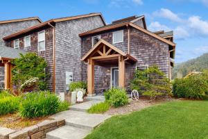 a house with a stone pathway leading to the front door at Lake Front Townhome - Rockaway Beach in Rockaway Beach