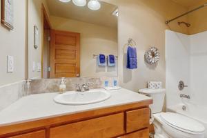 a bathroom with a sink and a toilet and a mirror at Lake Front Townhome - Rockaway Beach in Rockaway Beach +21 photos