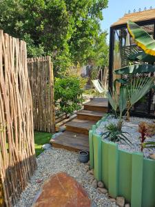 a garden with a wooden fence and a wooden staircase at L orangerie de casaoma in Prunelli-di-Fiumorbo
