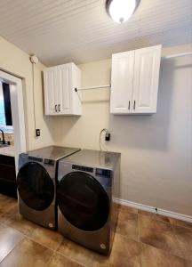 a washer and dryer in a kitchen with white cabinets at Craftsman by Downtown Uvalde in Uvalde