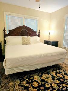 a bedroom with a large bed with a wooden headboard at Craftsman by Downtown Uvalde in Uvalde