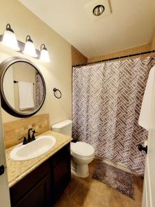 a bathroom with a toilet and a sink and a shower at Craftsman by Downtown Uvalde in Uvalde +17 photos