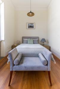 a bedroom with a bed with a blue couch at Vila Mar Beach House in Arcozelo +42 photos